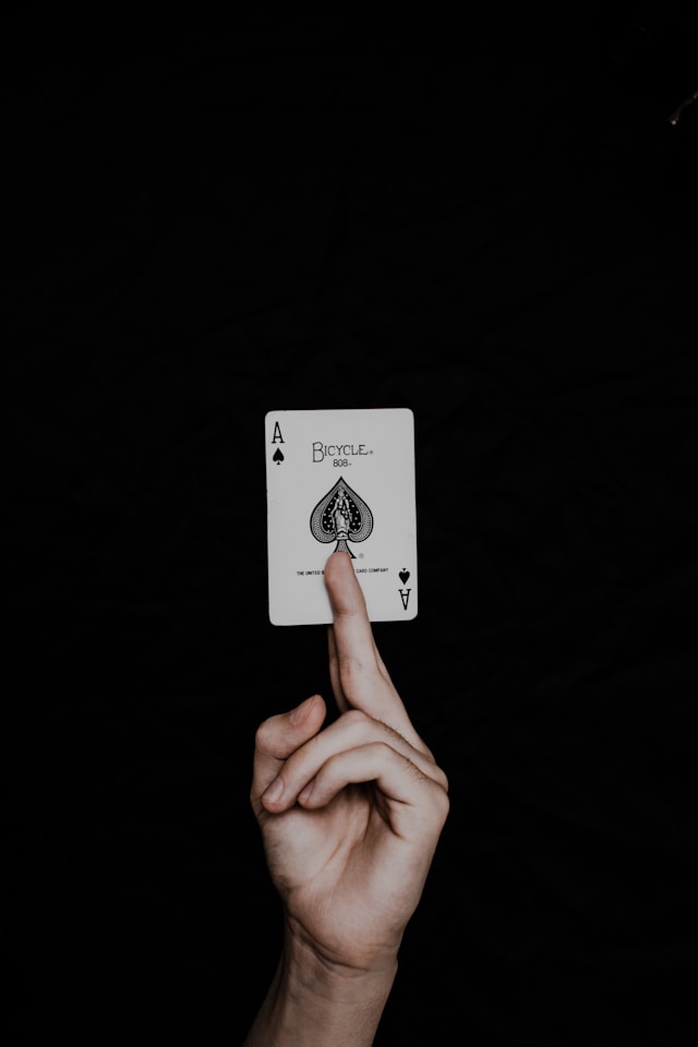 Trump card between two fingers with black background