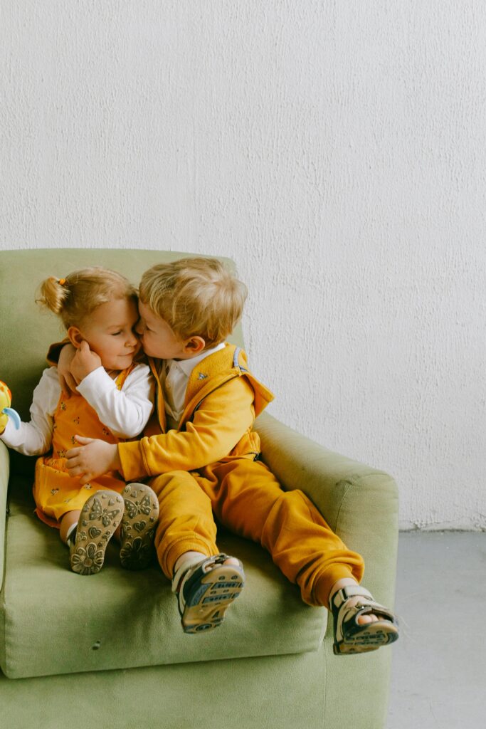 siblings sitting on a chair together loving each other