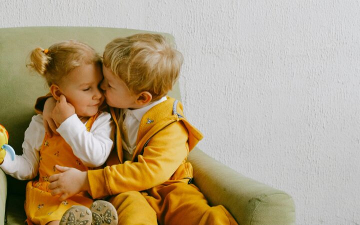 siblings sitting on a chair together loving each other