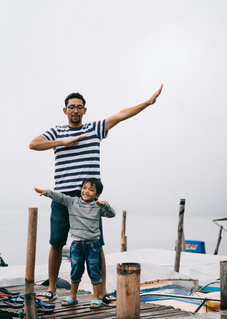 Father learning a dance from his little kid