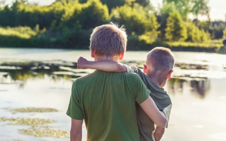 brothers together by a lake
