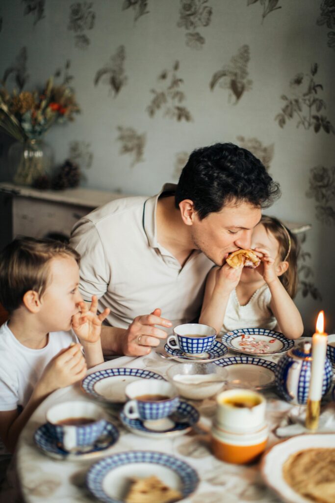 father fulfilling the role of the father as he has breakfast with his kids