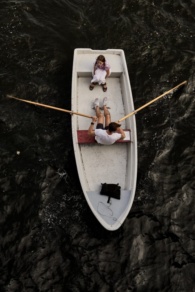 father fulfilling his role as a father by teaching his daughter how to row a boat